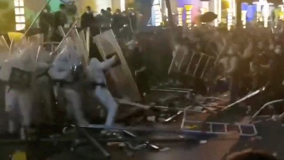 애플 협력업체 폭스콘의 중국 정저우 공장 직원들이 23일 경찰과 충돌하고 있다. AP=연합뉴스