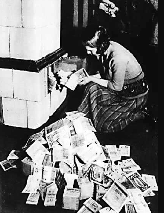 A German woman lights a fire with worthless banknotes, 1923