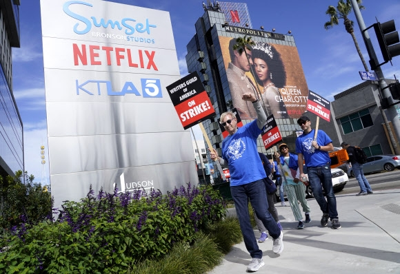 ▲ 미국작가조합(WGA) 파업에 참여한 작가들이 로스앤젤레스의 넷플릭스 본사 앞에서 피켓을 들고 구호를 외치고 있다 ⓒ 로스앤젤레스 AP 연합뉴스