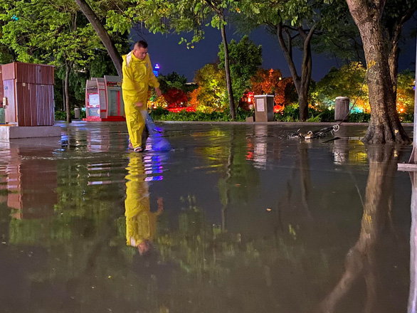 13일 저녁 호우 이후 환끼엠호 보행자거리 주변을 하노이 배수관리원들이 청소하고 있습니다