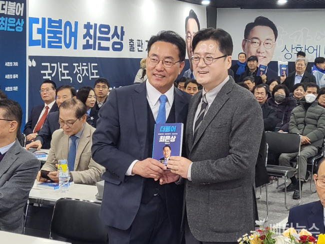 최은상 더불어민주당 서초갑 지역위원장(왼쪽)과 홍익표 민주당 원내대표가 6일 서울 ROTC 중앙회에서 열린 최은상 출판기념회에서 최 위원장의 저서를 함께 들고 사진을 찍고 있다. ©베타뉴스