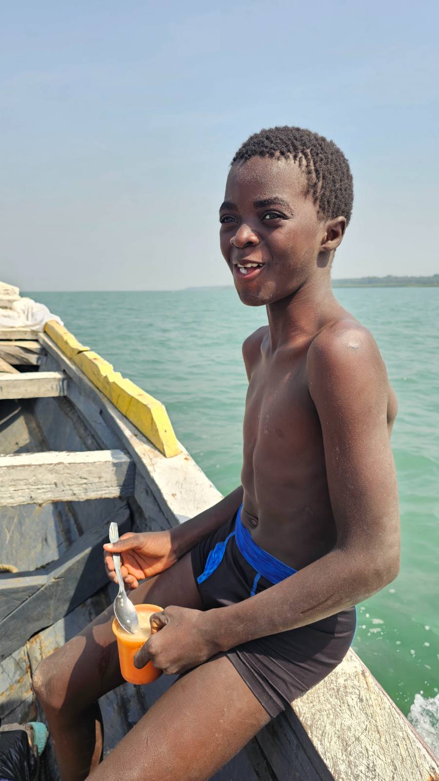 A child eating raw rice mixed with sugar due to a lack of food