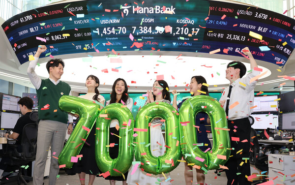 &nbsp; 6일 오후 서울시 중구 하나은행 본점 딜링룸에서 딜러들이 코스피 7000 시대 개막을 축하하고 있다. [사진: 하나은행]