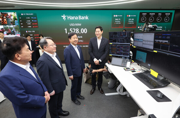 구윤철 부총리 겸 재정경제부 장관, 권민수 한국은행 부총재보, 함영주 하나금융 회장이 24시간 외환시장 개장 첫날인 6일 서울 중구 하나은행 본점 딜링룸을 방문해 외환 거래 과정에 대해 설명을 듣고 있다. [사진: 연합뉴스]