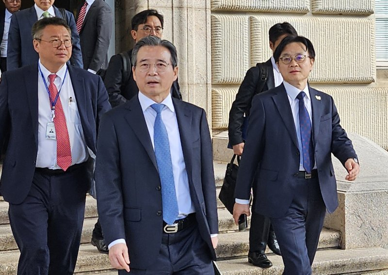 22일(현지시간) 미국 워싱턴DC 미 상무부 청사에서 하워드 러트닉 상무장관을 만난 김용범 대통령실 정책실장(가운데)과 김정관 산업통상부 장관(오른쪽 첫번째)이 걸어나오고 있다. 김 실장은 