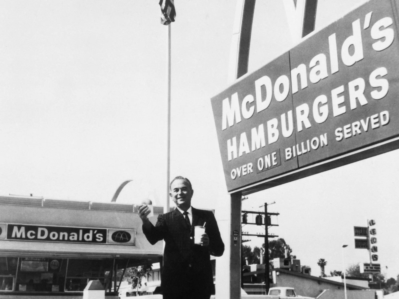 출처: Business Insider (Ray Kroc, founder and chairman of McDonald's Corporation, stands outside one of his franchises, holding a hamburger and a drink.Bettman/Getty Images)