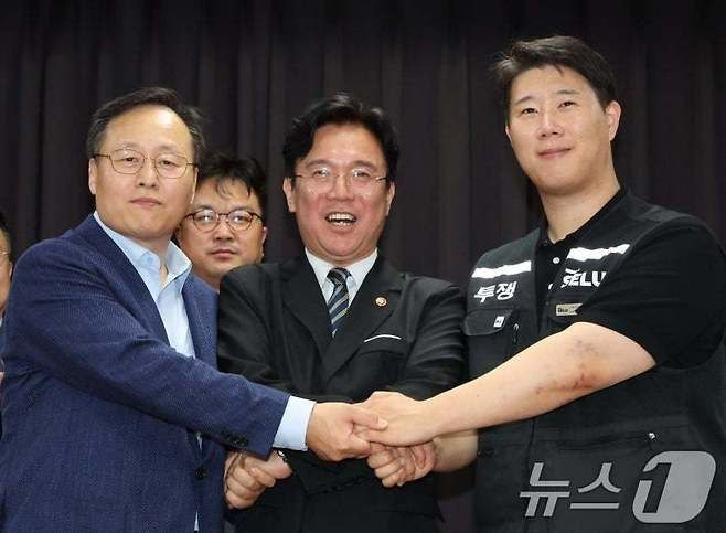 여명구 삼성전자 DS(디바이스솔루션·반도체 사업 담당) 피플팀장(왼쪽부터)과 김영훈 고용노동부 장관, 최승호 삼성그룹 초기업노동조합 삼성전자지부 위원장이 잠정 합의안에 서명한 후 손을 맞잡고 있다. ⓒ 뉴스1
