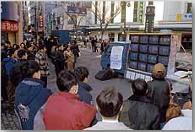 <b>▲ 노동자 총파업 승리를 위한 공동영상제작단(1997)이 집회 현장에 마련한 '명동 민주방송국' 화면을 유심히 지켜보는 사람들 (사진 출처: 한겨레21)</b>