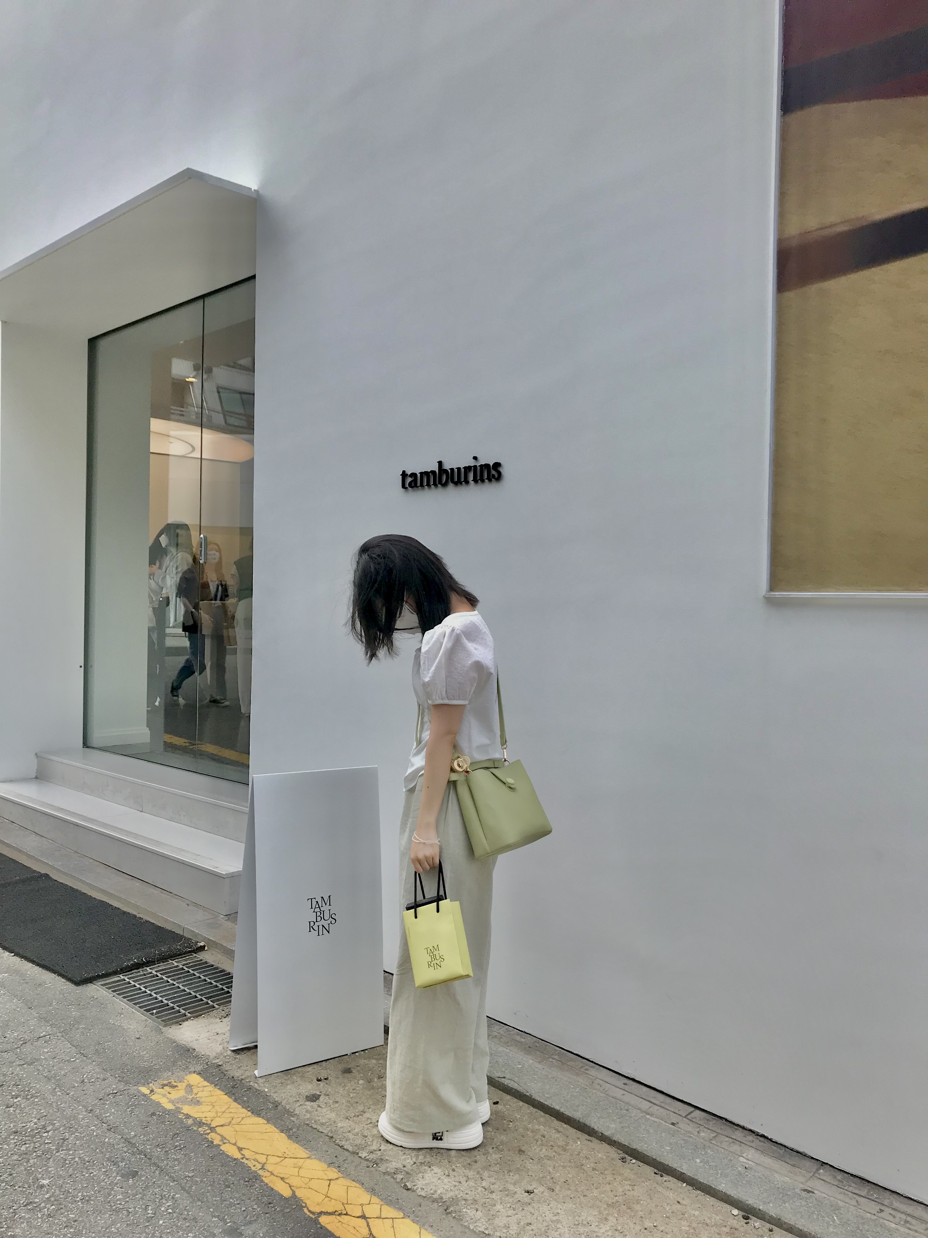 하얀 외관과 감각적인 포스터가 걸린 탬버린즈 쇼룸 앞