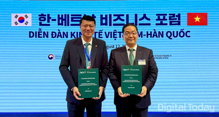 하나은행은 지난 12일 서울시 롯데호텔 본관 크리스탈볼룸에서 열린 ‘한국‑베트남 비즈니스 포럼’에서 베트남투자개발은행(BIDV)과 '국가 간 QR결제 서비스 활성화를 위한 업무협약'을 체결했다. 이날 행사에 참석한 이호성 은행장이(오른쪽) 레 응옥 람 베트남투자개발은행장(사진 왼쪽)과 함께 협약서를 들고 기념촬영을 하고 있다.  [사진: 하나은행]