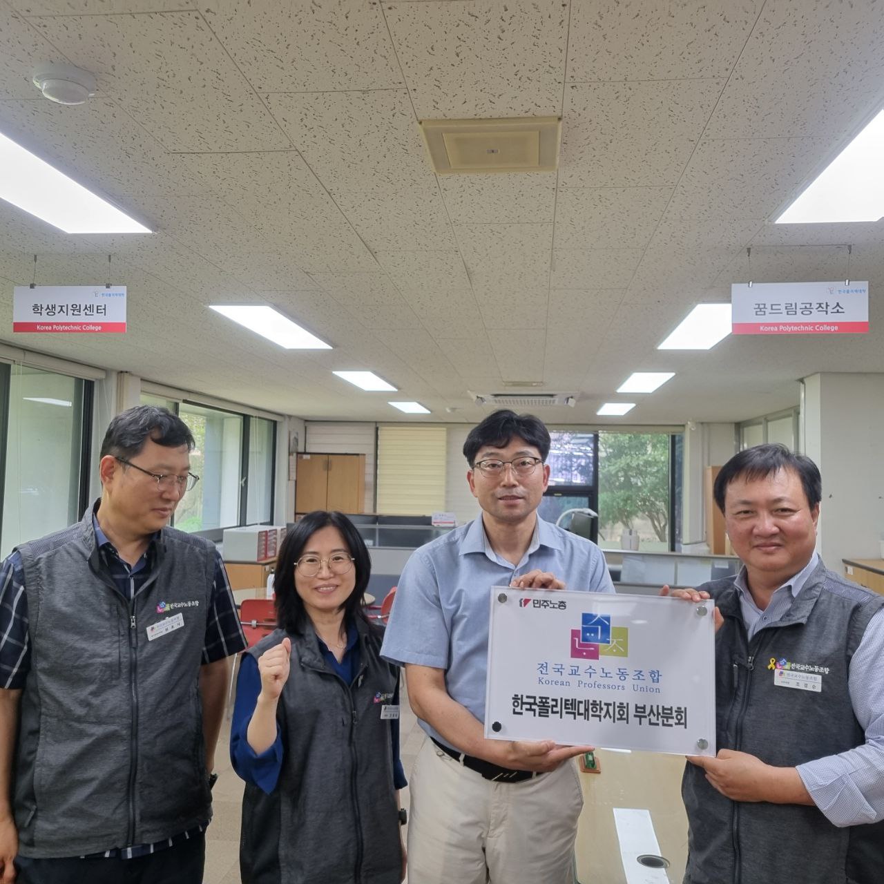 교수노조 조경순 사무처장이 전용숙 부위원장과 함께 분회 간판을 전달하고 있다