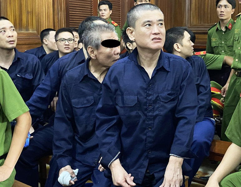 법정에서 피고 리 티엔관(우측)과 김순식(가운데) 및 다른 피고들