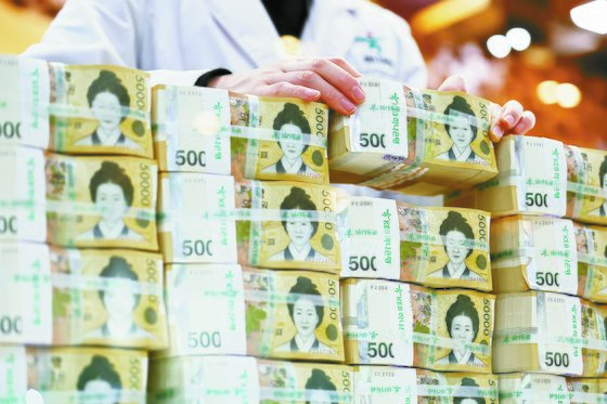 고금리 시기에는 현금 창출력이 좋은 기업이 주목 받는 경향이 있다. 서울 중구 하나은행에서 한 관계자가 5만원권을 보이는 모습. 연합뉴스.