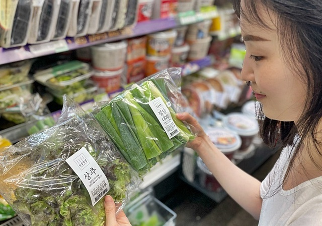 [출처: BGF리테일] 소포장 채소를 고르고 있는 소비자.